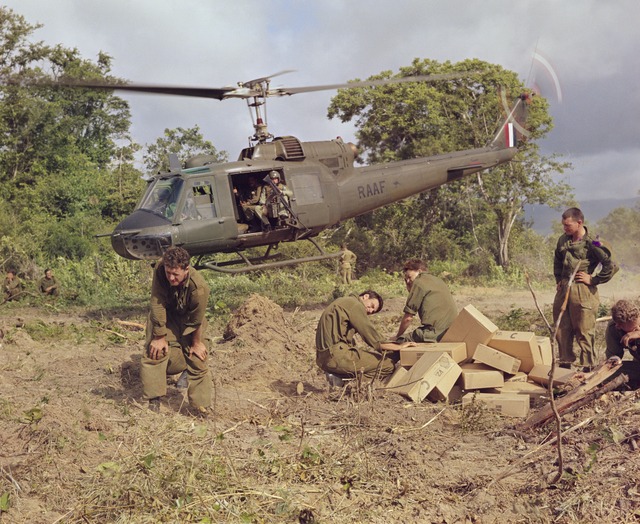 Australian soldiers unloading supplies beside an RAAF Iroquois helicopter in Vietnam, 1967