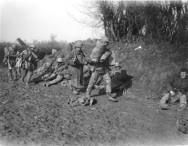 Australian machine gunners moving up near Bapaume, France, in 1917, one carrying a Vickers gun